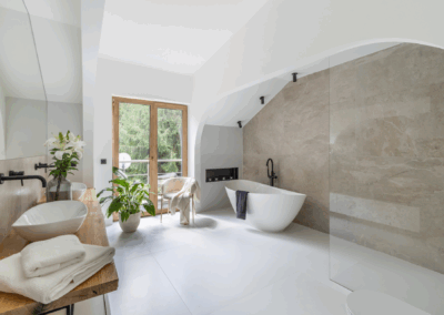 Przestronna łazienka z dużym oknem, wanną wolnostojącą, prysznicem walk-in i dwiema umywalkami, zaprojektowana z myślą o świetle i nastroju.