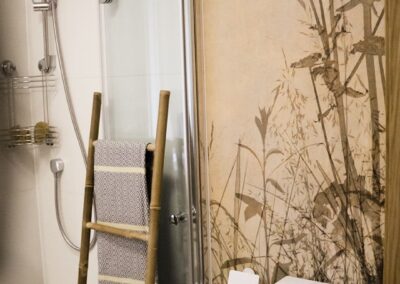 Mała łazienka z tapetą, składanym prysznicem i odpływem liniowym w domu letniskowym z lat 80. w Zalesiu.