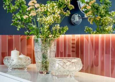 Detal prywatnej łazienki przy sypialni rodziców — marmurowy blat, kolorowe płytki i ciemna ściana w apartamencie na Ursynowie.