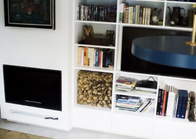 Nowoczesny, ekologiczny kominek w domu letniskowym z lat 80. — zintegrowany z zabudową i otoczeniem.