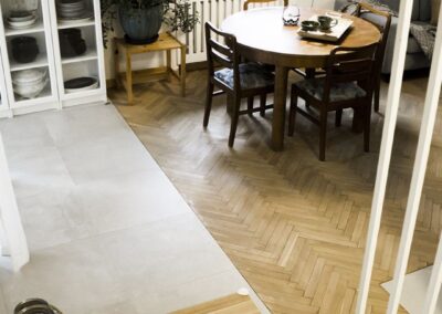 Salon w domu z lat 80. w Zalesiu z odnowionym parkietem w jodełkę, naturalnym światłem i detalami w duchu zero waste.