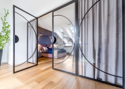 Widok na sypialnię z antresoli — loftowa ścianka z podziałami, naturalne światło i detal w apartamencie na Ursynowie.